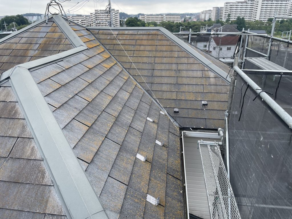 経年劣化したスレート屋根。苔や色あせが目立ち、雨漏りリスクが高まっている様子。
