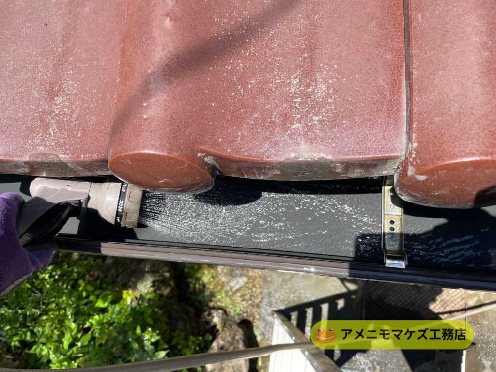 雨どい清掃後に散水を行い排水状況を確認している様子
