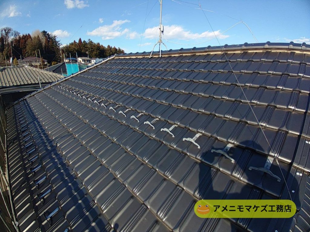 割れた瓦を差し替え補修し、瓦屋根の修理が完了した様子